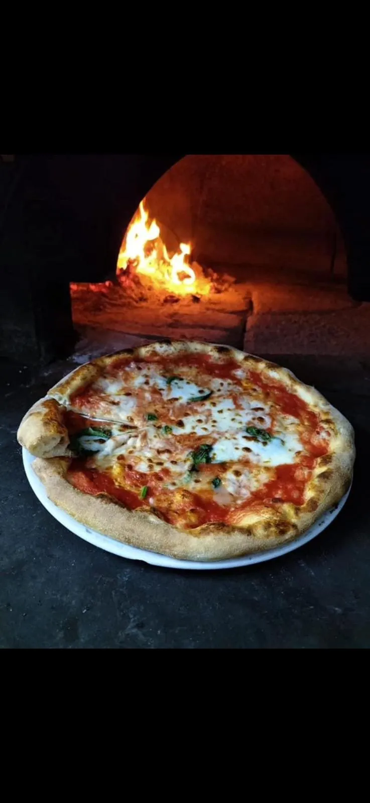 Pizza cotta nel forno a legna